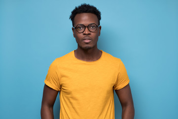 Fototapeta premium Smart young african american man in glasses looking confident at camera