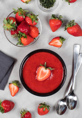 Strawberry soup-puree in a bowl top view on a light gray background