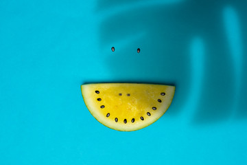 Watermelon Slice With Smile Made Of Seeds on Blue Turquoise Background With Exotic Palm Tree...