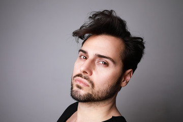 Obraz premium Portrait of 30-year-old man standing over grey background in denim shirt. Close up. Copy-space. Studio shot.