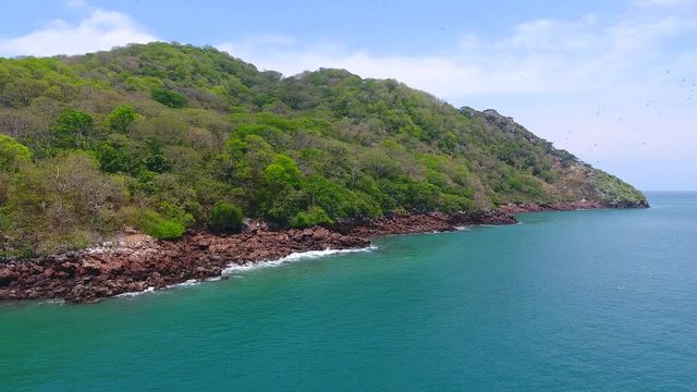 Waves Crashing on Rocks with Frigates and Pelicans on Green Bona Island, Panama