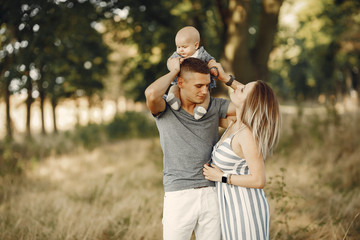 Family with cute little son. Father in a gray shirt. Lady in a dress