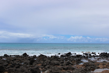 Fototapeta na wymiar Tropical beach against the rocks