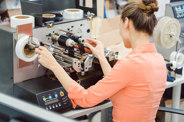 Woman working on label printing machine