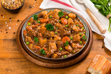 Beef Curry Stew with Potatoes and Carrots on Wooden Background. Selective focus.
