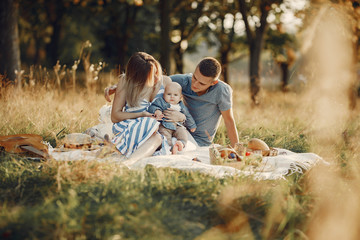 Family with cute little son. Father in a gray shirt. Family on a picnic sitting on a blanket