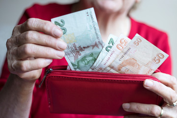 woman holding Turkish lira banknotes