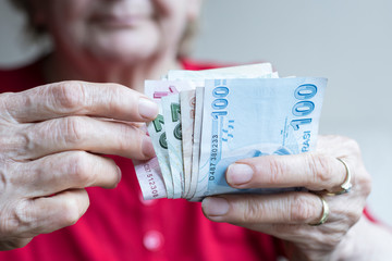 woman holding Turkish lira banknotes