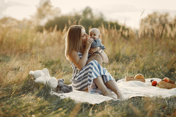 Family in a autumn park. Mother in a striped dress. Cute little boy