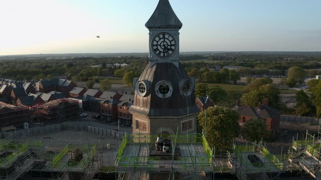 Aerial footage of military hospital clocktower being repaired during summer sunset in England
