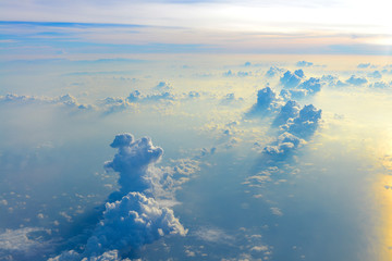 Naklejka premium Sun rise in the morning of blue sky above the white clouds and land background with golden light looking through an airplane window