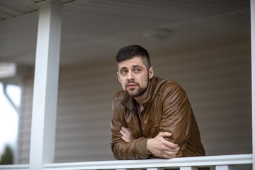 Fototapeta premium portrait of a man on the veranda of his house