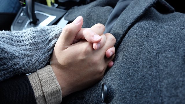 Cropped Image Of Couple Holding Hands In Car