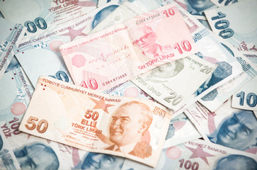 Obraz na płótnie Canvas Many hundred Turkish lira on wooden table background texture. bundles of money scattered on the office desk. wealth and income concept. Counting money. 