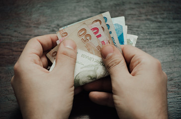 Many hundred Turkish lira on wooden table background texture. bundles of money scattered on the...