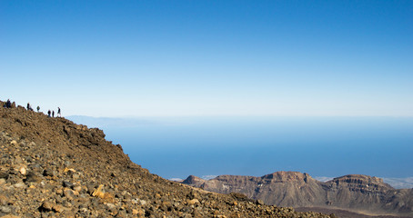panoramic from the teide volcano with a blue sky and many rocks with the canary islands in the background
