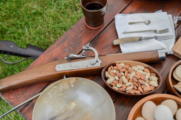 Antique tools, historic items, period ingredients, vintage musket gun, and equipment on table display for old wooden rustic background top view