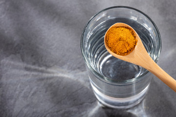 Spoon with turmeric powder to mix with water - Curcuma longa