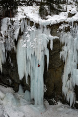 un homme escaladant une cascade de glace 