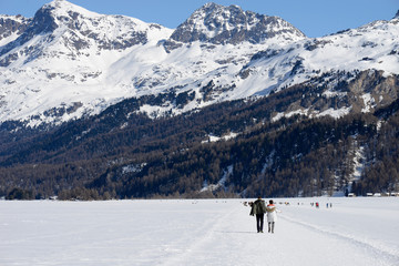 Fototapeta na wymiar couple en randonnée sur un lac gelé - Suisse