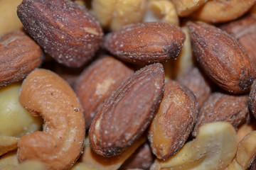 Close up of salted Almonds and Cashews pile background. Mixed nuts delicious snack food wallpaper