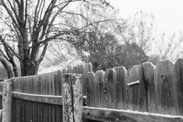 Wooden fence picket and posts under snow covered at residential area suburbs Dallas, Texas, USA