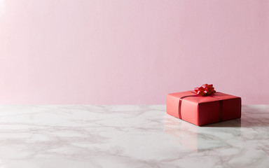 赤い包装のプレゼントボックスとピンクと大理石のツートンと背景の写真