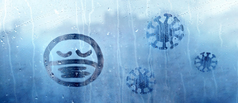 sad face with closed eyes in protective medical mask and three coronavirus molecules figure is painted on wet blue window with raindrops concept photo self-isolation, banner, covid - 19