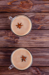 Glass cups of traditional indian tea masala tea on wooden background, rustic table
