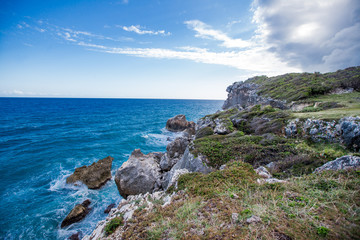 Fototapeta na wymiar Meadow sea sky cliff landscape at Caribbean coast with green forest rocks and dramatic clouds in Dominican republic