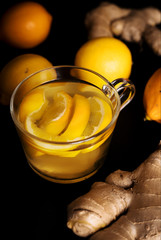mug of tea with cut lemon and ginger root