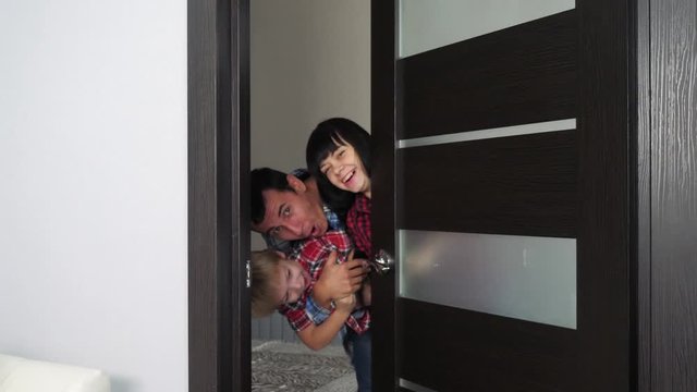 Happy Family Opens The Cheerful Door. Mom Dad And Son In A New Apartment. Man And Family Open Their House Lifestyle Smiling Joy