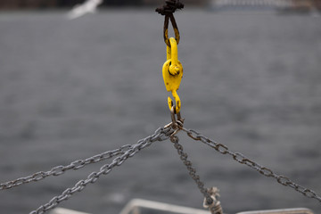 The metal chain is used for lifting weights. In the background the sea is blurred.