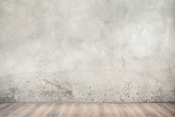 Vintage old grunge stained concrete wall and textured aged wooden floor. Industrial or loft design background. Retro style filtered photo