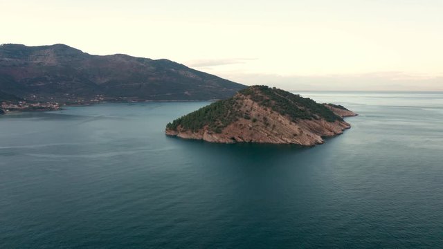 Drone flight around the mountain slopes and rocky coastline of Thasos island and the little island Nisida Kinira, Greece