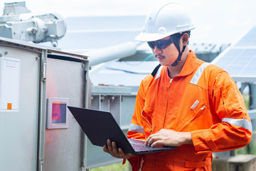 Engineers used a laptop for checking the performance of the controller box to confirming systems working normally. Concepts professional engineer for the Solar cell power plant