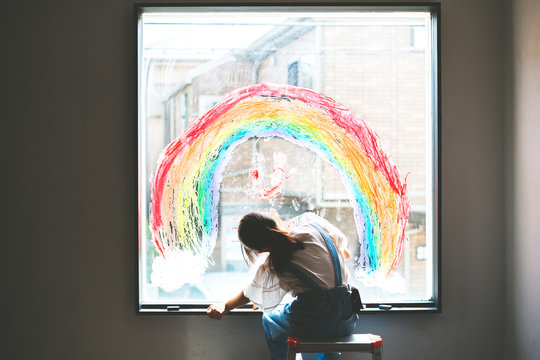 窓に虹を描く少女