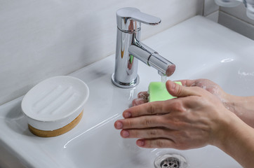 Hand washing with soap. Preventive measures against infection. A young guy washes his hands with...