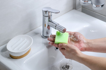 Hand washing with soap. Preventive measures against infection. A young guy washes his hands with...