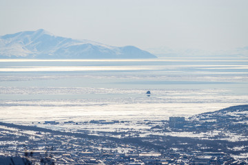 View of the sea bay and mountains. Ice floes on the surface of the sea. The end of April in the north-east of Russia. Gertner Bay, Sea of ​​Okhotsk. Magadan, Magadan Region, Siberia, Russian Far East.