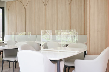 Social distancing. Table with plastic shield as a protection from Covid-19.