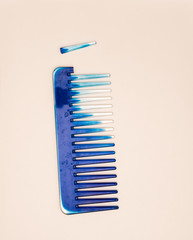 Blue woman's comb with broken piece isolated against a white background. It illustrates bad product quality.