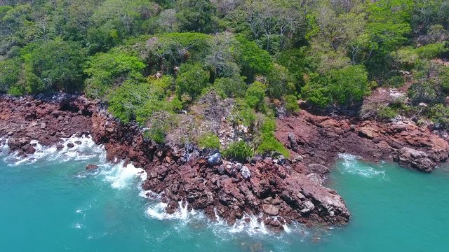 Waves Crashing on Rocks with Frigates and Pelicans on Green Bona Island, Panama
