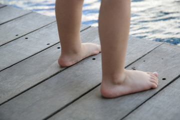 Barefoot toddlers feet standing on the wooden floor