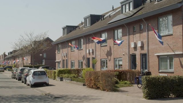 Houses in suburban neighborhood decorated with Dutch flags during Kingsday in the Netherlands