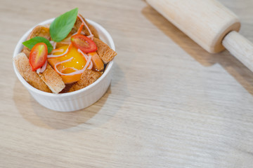 Homemade tomato egg cup delicious breakfast on wooden table with egg bread and rolling pin with copy space. Cooking at home concept.