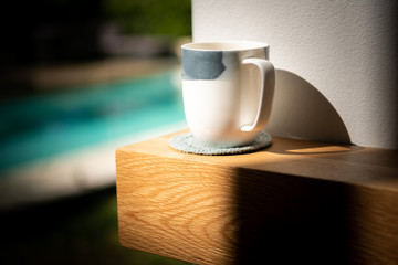 Cup of tea sitting on a solid wood American Oak mantle piece above a fireplace