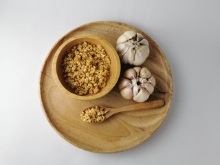 Fresh garlic in a wooden tray, Fried garlic wooden spoon and wooden cup 