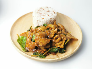 Stir fried bacon with basil and three color rice in a wooden plate on white background 