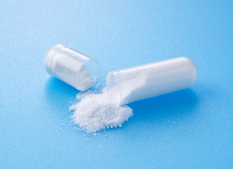 White capsules placed on blue background